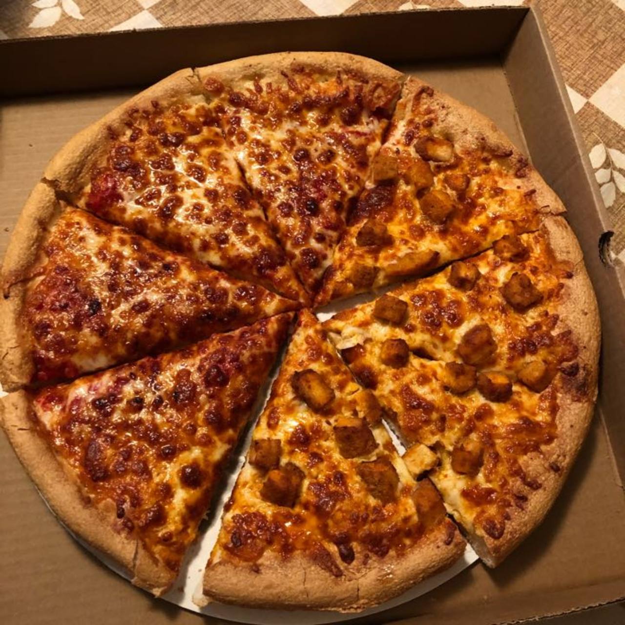 Cheese and buffalo chicken pizza in a takeout box.
