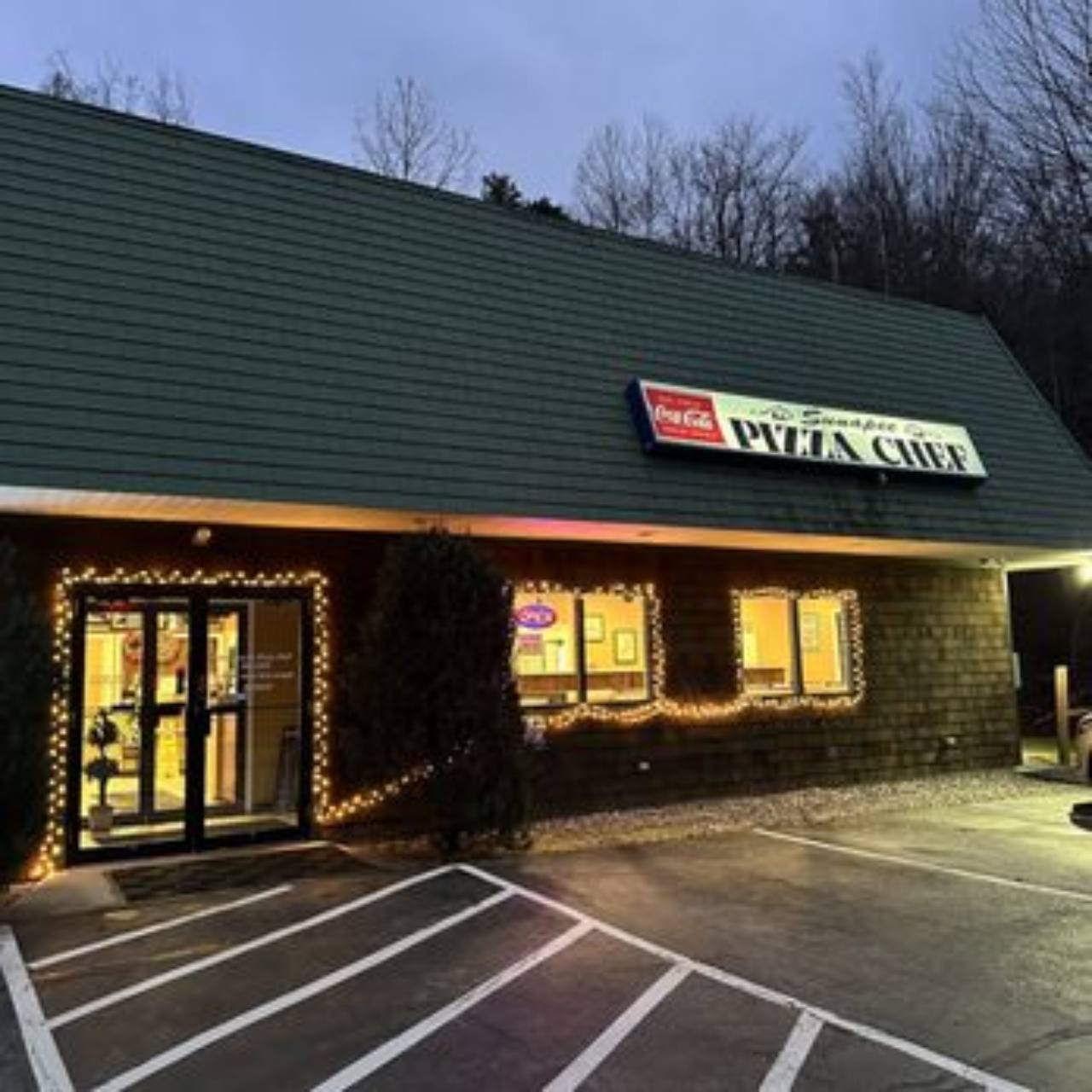 Sunapee Pizza Chef storefront illuminated at dusk.